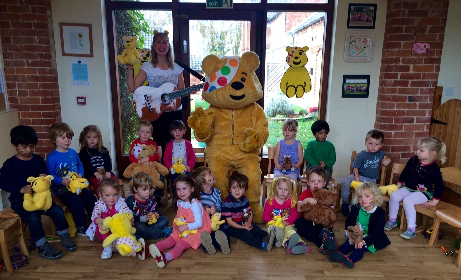 Nursery children gathered with Pudsey Bear and their teacher